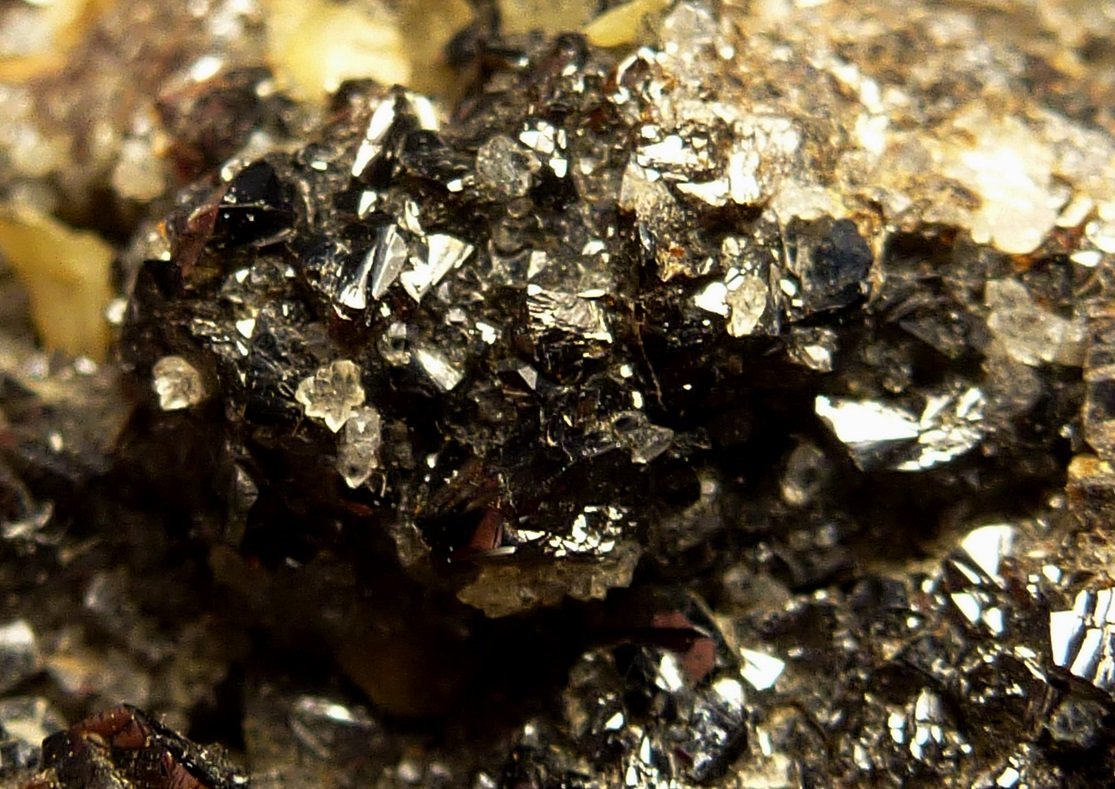 Esfalerita (variedad esfalerita rubí), Siderita, Calcita
6 x 4 cm.  la pieza, 1 x 1 cm. la zona de cristales
(Autor: javier ruiz martin)