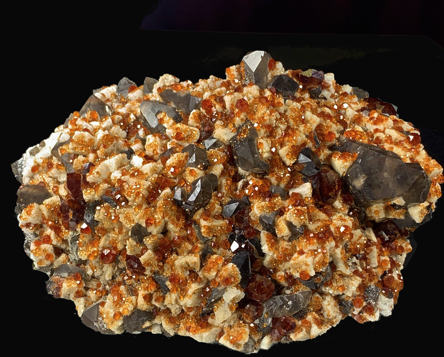 Spessartina (grupo Granate), Cuarzo (variedad ahumado), Feldespato
12,1 x 8,3 cm.
(Autor: Xavier bordas)