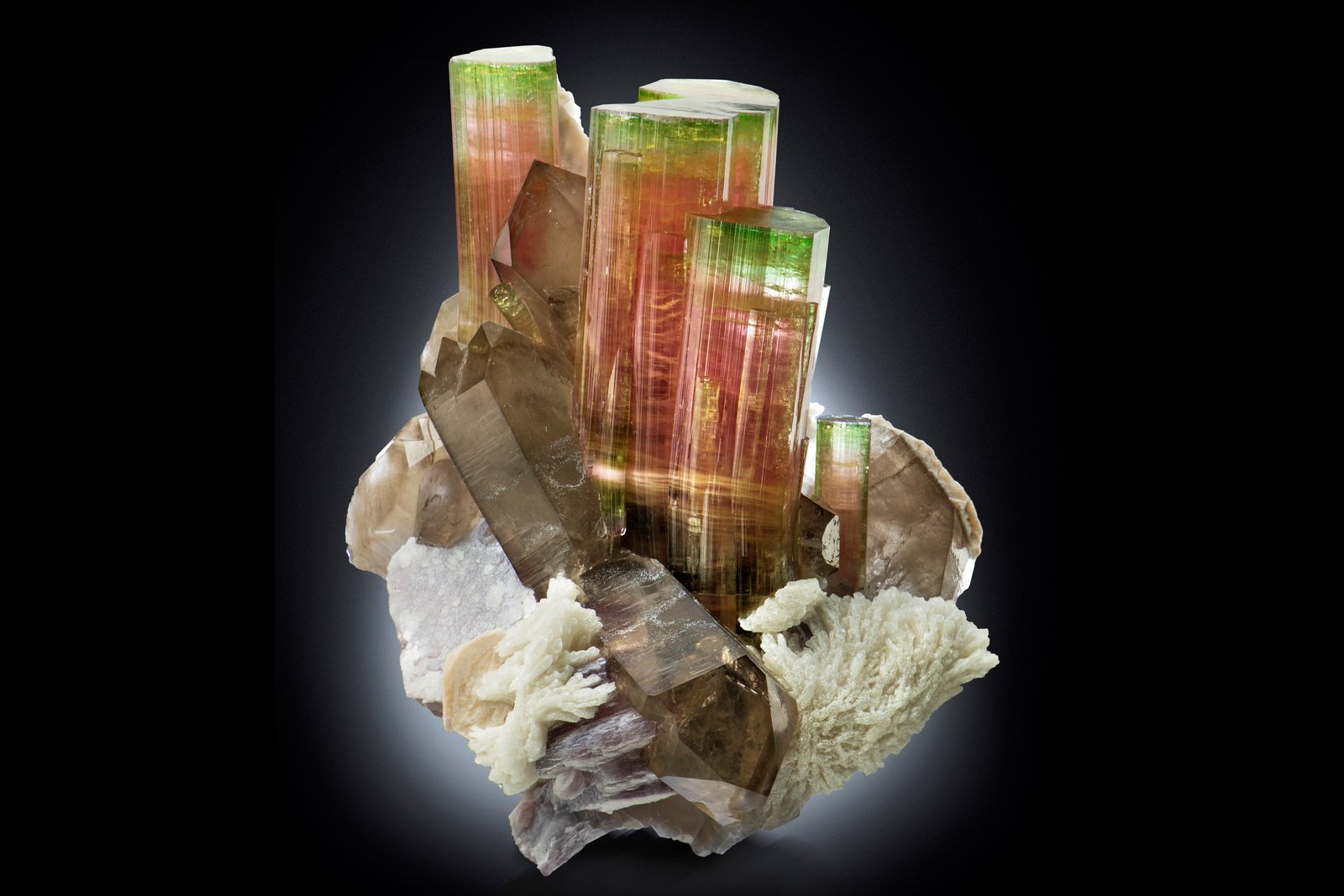 Elbaíta con Ortoclasa, lepidolita, Albita y Cuarzo (variedad ahumado)
14.5 x 12 x 16 cm / cristal principal: 9.2 cm
(Autor: Museo MIM)