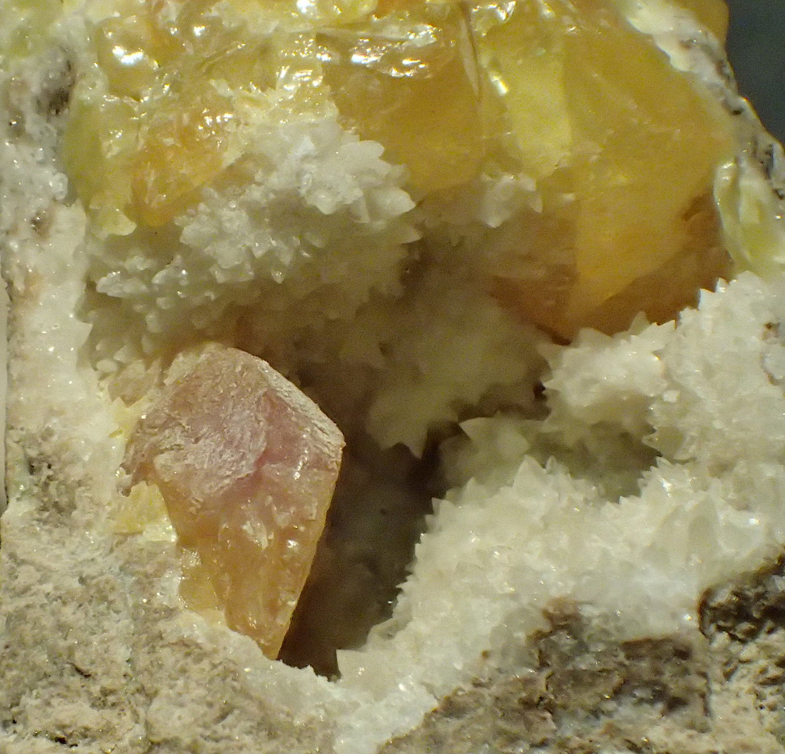 Azufre, calcita
0,7 x 0,4 cm (cristal anaranjado)
(Autor: Frederic Varela)